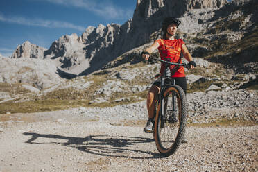 Frau mit Mountainbike im Nationalpark Picos de Europa an einem sonnigen Tag, Kantabrien, Spanien - DMGF00366