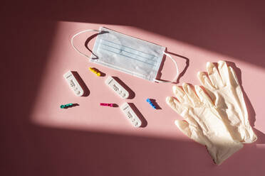 Studio shot of COVID-19 rapid diagnostic tests, pair of surgical gloves and protective face mask - MAUF03643
