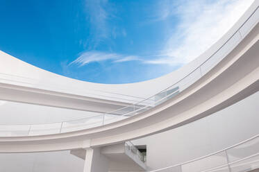 Low angle white minimalist building wall in futuristic style with narrow inclined ramp located under blue sky - ADSF18192