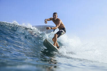 Mann balanciert beim Surfen im Meer gegen den klaren Himmel - KNTF06005