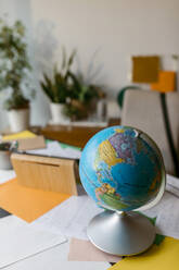 World globe with papers on table - VABF04072