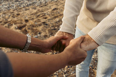 Young couple holding hands at beach - VABF04193