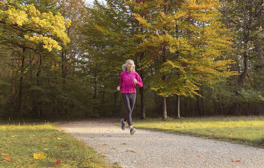 Frau joggt im Park gegen Bäume - FCF01920