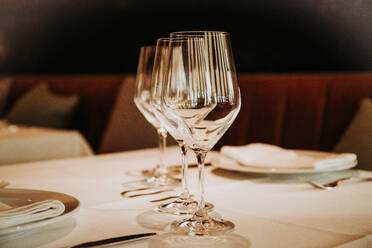 Glänzende Kristallbierkelche in einer Reihe auf einem Tisch mit Besteck zum Abendessen in einem Restaurant in Madrid - ADSF18297