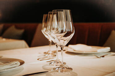 Shiny crystal beer goblets arranged in row on table with cutlery served for dinner in restaurant in Madrid - ADSF18297