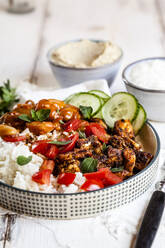 Bowl of Greek gyro with rice, fava beans, halloumi cheese, tomatoes and cucumbers - SBDF04436