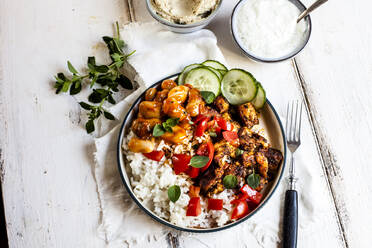 Bowl of Greek gyro with rice, fava beans, halloumi cheese, tomatoes and cucumbers - SBDF04440