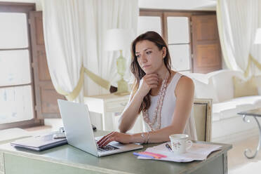 Businesswoman working on laptop while sitting at home - EIF00322