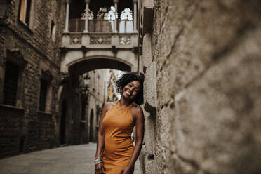 Smiling woman leaning on wall, Barcelona, Spain - GMLF00878