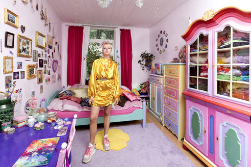 Beautiful woman wearing yellow dress in flashy bedroom at home - FLLF00522