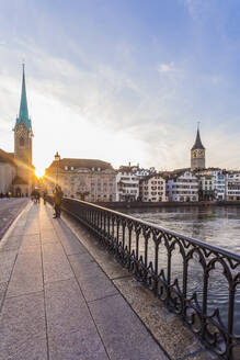 Schweiz, Kanton Zürich, Zürich, Münsterbrücke bei Sonnenuntergang mit Gebäuden am Flussufer im Hintergrund - WDF06405