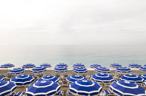 Leere Liegestühle und Sonnenschirme am Strand der Côte d'Azur - WDF06416