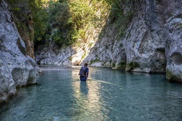 Mann wandert durch den Fluss Acheron in Epirus, Griechenland - MAMF01455