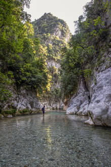 Mann steht im Fluss Acheron am Berg in Epirus, Griechenland - MAMF01458