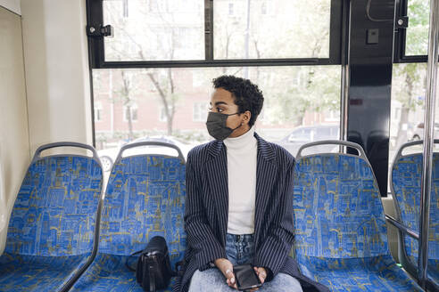 Young businesswoman traveling in bus during COVID-19 - VYF00285