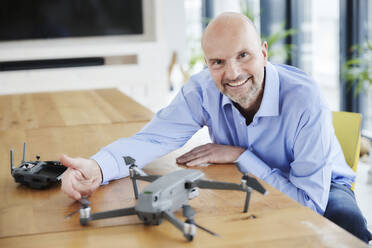 Lächelnder Mann überprüft Quadcopter - FMKF06820