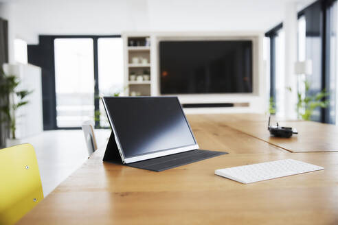 Digitales Tablet und weiße Tastatur auf dem Tisch im Heimbüro - FMKF06821