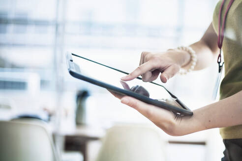 Geschäftsfrau benutzt digitales Tablet im Büro - AJOF00800