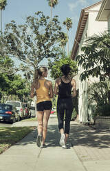 Multiethnische Freunde joggen an einem sonnigen Tag durch die Straßen - AJOF00947