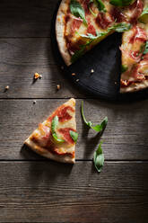 Top view of delicious pizza decorated with fresh basil and arugula leaves - ADSF18601