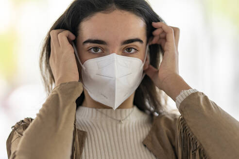 Junge Frau trägt Schutzmaske während der Pandemie - GGGF00291