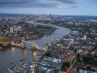 UK, England, London, Blick aus dem Hubschrauber auf die Themse, die Tower Bridge und umliegende Gebäude in der Abenddämmerung - HNF00824