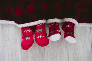 Mann und Frau tragen Weihnachtssocken zu Hause während der Weihnachtszeit - EBBF01694