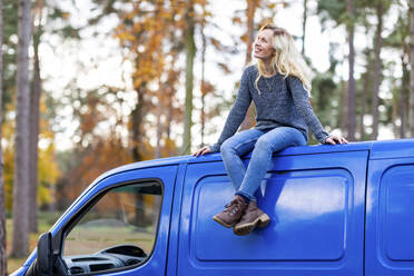 Happy woman on roof top of camper van at Cannock Chase - WPEF03775