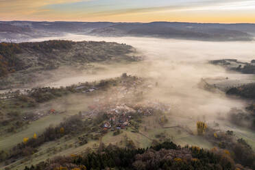Drohnenansicht des morgendlichen Nebels, der das Dorf im Wieslauftal einhüllt - STSF02705