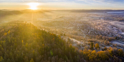 Drone Blick auf Herbst Wald bei nebligen Sonnenaufgang mit Dorf im Hintergrund - STSF02708