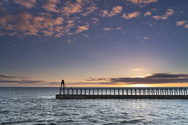 Sonnenaufgang über der Nordsee und dem Hafen und den Piers von Whitby im Spätsommer, Whitby, North Yorkshire, England, Vereinigtes Königreich, Europa - RHPLF18461