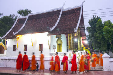 Buddhistische Mönche erhalten Reis von Einheimischen während eines täglichen Rituals am frühen Morgen, das als Sai Bat (Morgengabe) bekannt ist, in Luang Prabang, Laos, Indochina, Südostasien, Asien - RHPLF18497