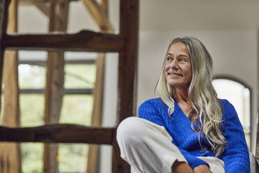 Smiling mature woman with gray hair looking away at home - MCF01535