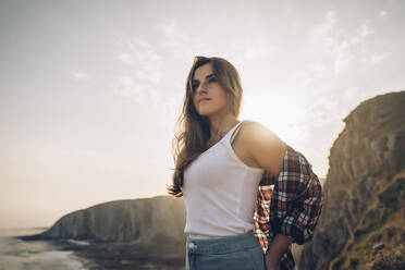 Woman looking away while standing against sky - MTBF00752