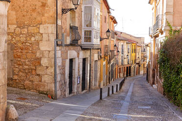 Spanien, Provinz Burgos, Lerma, Alte Häuser entlang einer leeren Kopfsteinpflasterstraße - DSGF02348