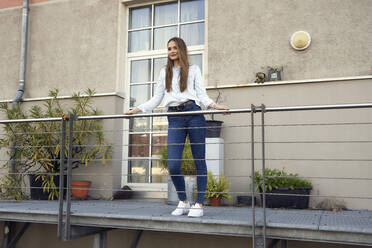 Businesswoman standing looking away while standing in balcony - RHF02477