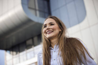 Smiling businesswoman looking away while standing outdoors - RHF02500