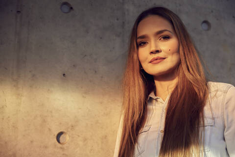 Young beautiful businesswoman standing against wall stock photo