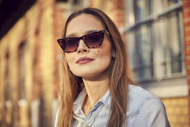 Geschäftsfrau mit Sonnenbrille stehend im Freien - RHF02518