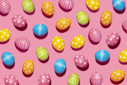 Handmade decorated Easter eggs on pink background - GEMF04447
