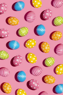 Colorful decorated Easter eggs on pink background - GEMF04448
