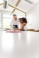 Geschäftskollegen verwenden digitales Tablet in einer Sitzung im Sitzungssaal - PESF02390