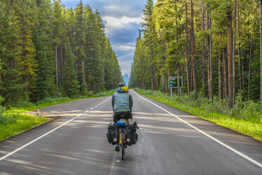 Mann beim Radfahren auf der Straße, Banff National Park, Alberta, Kanada - ISF24315