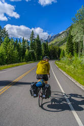 Mann beim Radfahren auf der Straße, Banff National Park, Alberta, Kanada - ISF24316