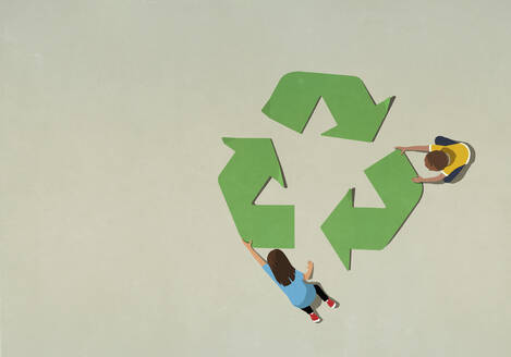 Junge und Mädchen beim Zusammenbau eines grünen Recyclingsymbols - FSIF05422