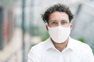 Male entrepreneur with protective face mask during COVID-19 - JOSEF02553