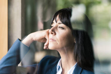 Thoughtful businesswoman seen through glass in office - JOSEF02574