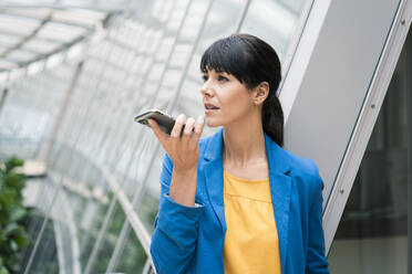 Female entrepreneur sending voicemail through smart phone - JOSEF02601