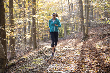 Sportler beim Laufen auf einem Wanderweg im Wald - JSRF01244