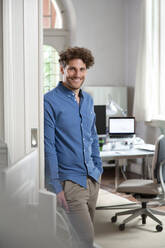 Smiling male professional with hand in pocket at office - FKF03866